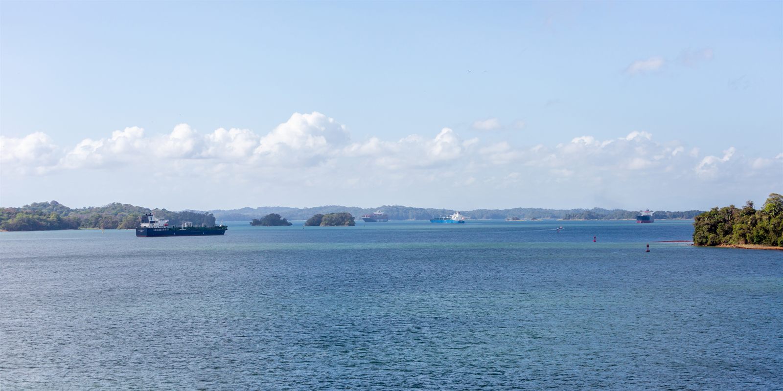 Ship on calm open water with islands on the horizon